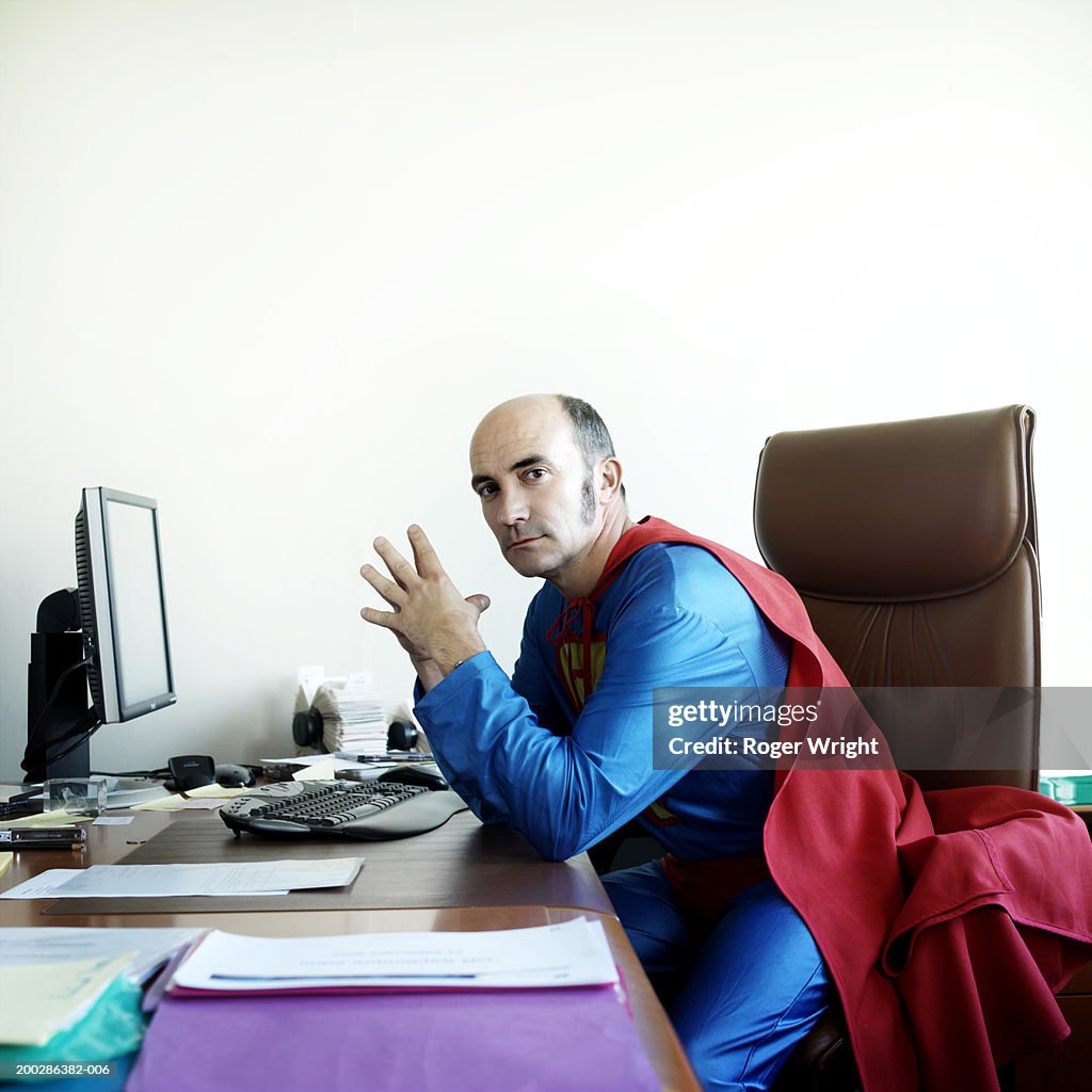 man-at-desk-in-superhero-costume-portrait.jpg